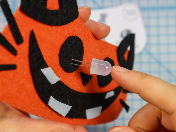 Insert each LED through the holes with the longer, positive leg in the top hole.