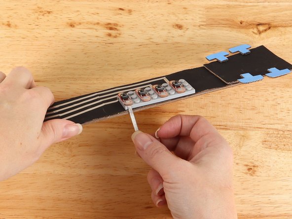 Replace the button to help secure the tape path in place.