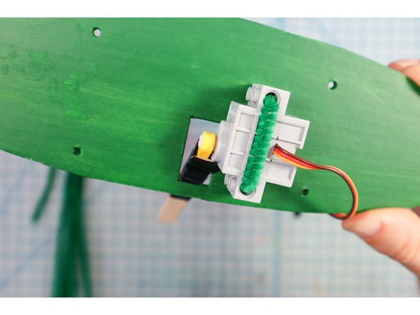 Connect the stick to the motor, placing it through the hole as shown.