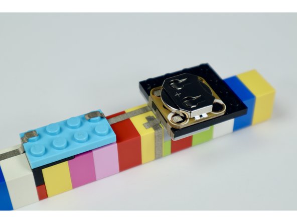 Taking care to orient each component as shown in the photos at left and press the battery holder, pushbutton and LED into place. 