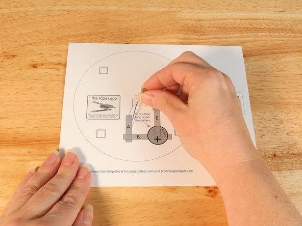 Stick the motor to the double sided tape making sure the back of the motor (with the wires) is stuck down to the tape and the part that spins faces upwards so it can move freely.