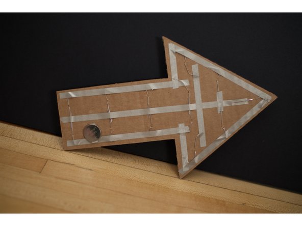 Use a short piece of tape to connect the center (positive) piece of tape to the top of the battery.