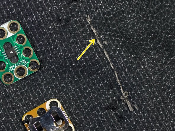 Turn the shirt inside out. Stitch the thread back along the path. Tie a knot and trim the thread as shown.