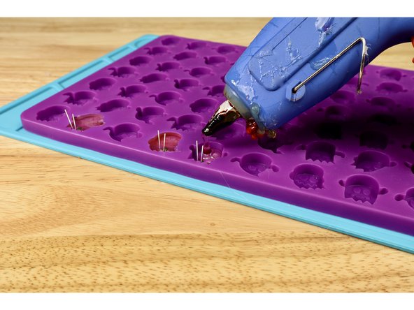 Now, with the lower portion of glue hardened, squeeze glue into the each of the mold cavities until they are filled to the top.