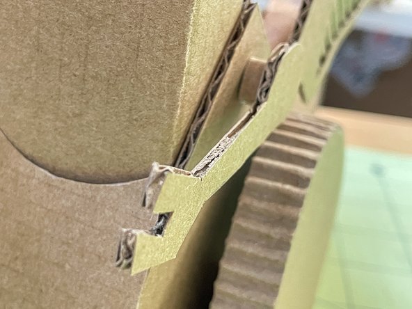 Glue the arms in place using a small curl of cardboard to give them a 3D look.