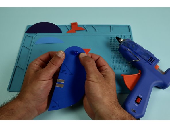 Use glue to assemble the tail, wing, feet, and beak to the body.