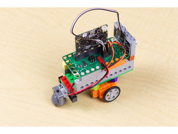 Plug the battery pack into the Bit Board and your robot should start rolling. If you put your hand in front of the sensor, it should back up, turn, and then move forward again. (Don't let it roll off of a table!)