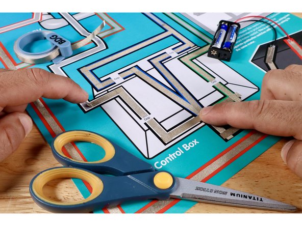Measure, cut, peel, and stick the 9 Maker Tape paths shown to complete the 2 branches of the blue path out of the control box. Take care to leave a tape-free gap where shown.