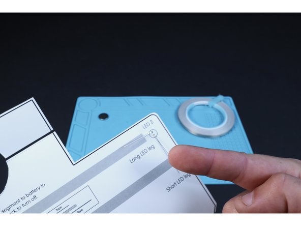 Flip your project over to the circuits side. Bend the LED legs in the directions shown on the diagram so they lay flat against the paper.