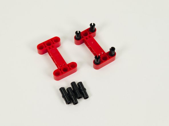 Insert four black pins into each of the red I-shaped beams as shown.