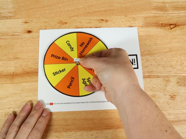 Add another square of double-sided tape onto the shaft of the motor, and then stick the arrow to it.