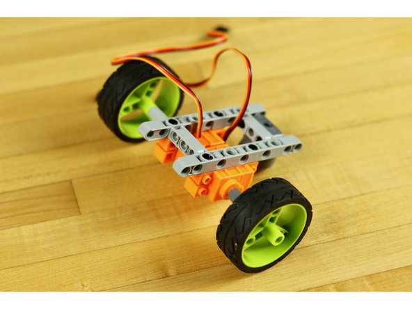 Tank treads are always the way to go if you can, but you'll need to make a larger body and you probably want to do some gear reduction to increase the power going into the system.