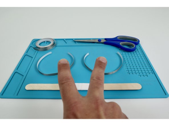 Measure and cut two separate Maker Tape pieces that are approximately the length of the wand handle you created.