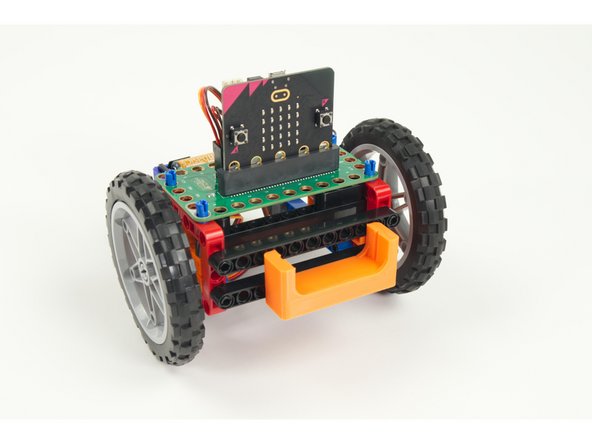 Slide the Distance Sensor Holder with pins into the beam on the front of the Rover as shown.
