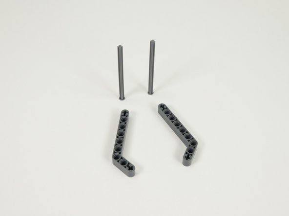 Start the assembly of the &quot;fingers&quot; by sliding the axles into the end of the  gray angled beams as shown.