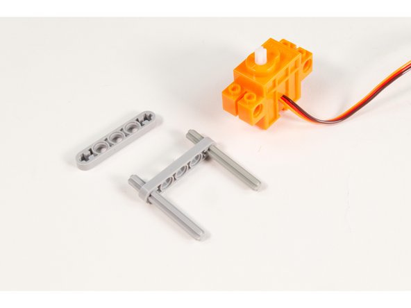 Press 2 LEGO Axle 6  parts through the ends of a LEGO Beam 5 x 0.5 with Axle Holes as shown.