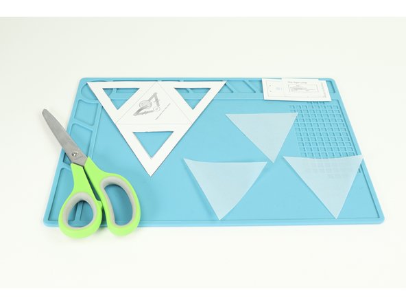 Use a black marker to create designs on your tracing paper triangles that break the triangles up into sections. Then color the sections in with markers as you wish.  Anything goes!