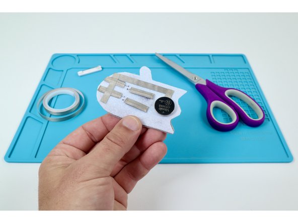 Stick your battery atop the Maker Tape Loop so the Positive (+) Side is UP.