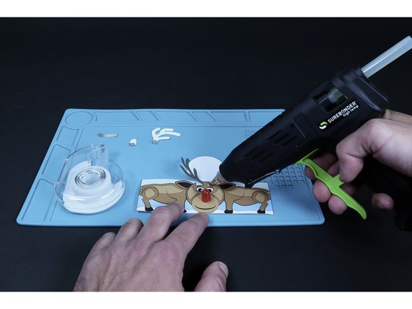 Glue the two antlers in place as pictured by applying a dot of hot glue to the striped areas on the tube body and pressing the folded, striped parts of the antlers to those areas.