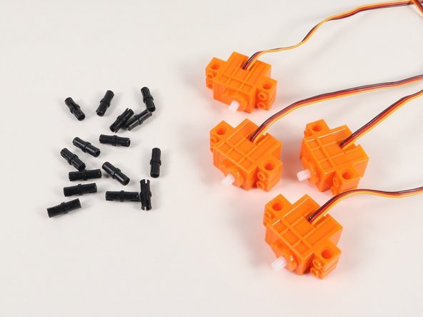 Add 4 black pins to a continuous rotation servo. You will need to do this to all 4 servos.