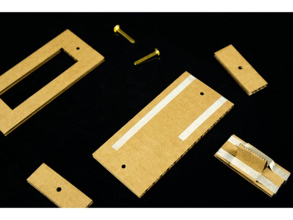 With all of your cardboard pieces prepared, you can now add strips of Maker Tape to the bottom piece.