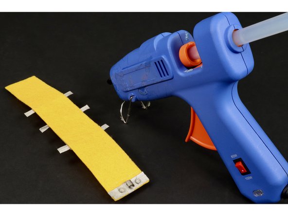 Continue by hot gluing the remaining portion of the conductive hook and loop on top using two dots of glue on either side of the tape loop. Remember: do NOT add hot glue on top of the loop...only the areas to the right and left of it.