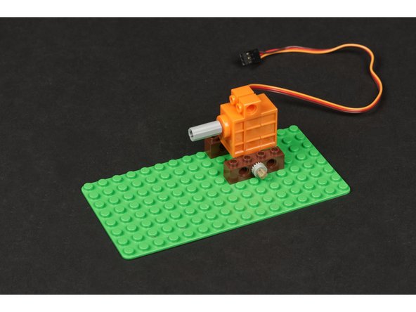 Next we'll attach the shaft and wheel/rim to the servo. You'll need an axle connector added to the servo shaft to start.