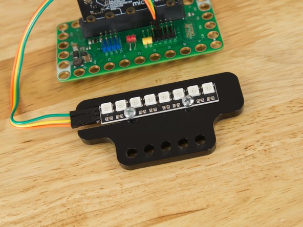 If you have a Bit Board Rover your Addressable RGB LED Strip came attached to a piece of acrylic. This allows it to attach to the front of the Rover using two black pins.