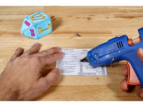 Squeeze a dot of hot glue onto the motor graphic of your circuit baseplate.