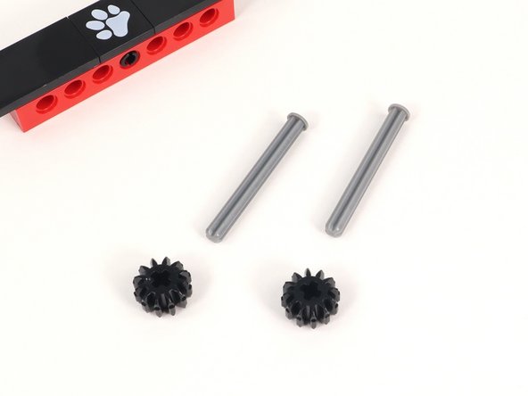 Add a small black gear to an axle with end stop and push it all the way down to the end stop. You will need two of these.