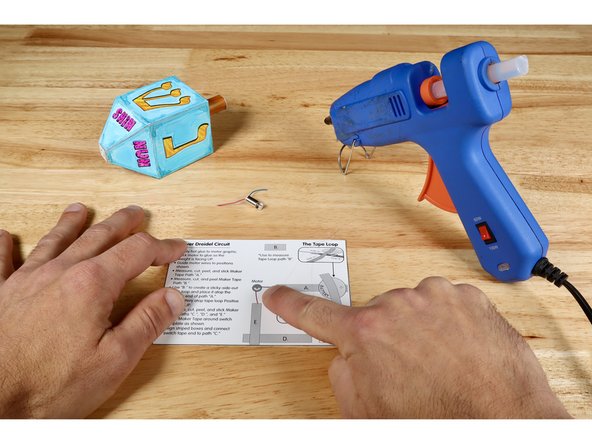 Gather the circuit baseplate, your motor and the hot glue gun.