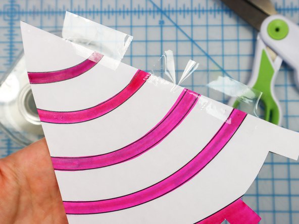 Add tape to one side of the horn piece so that it goes off the edge as shown.