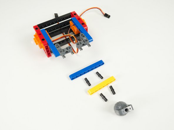 There are two more beams to attach, each using two pins, and then we can add the caster wheel to the back of the rover.