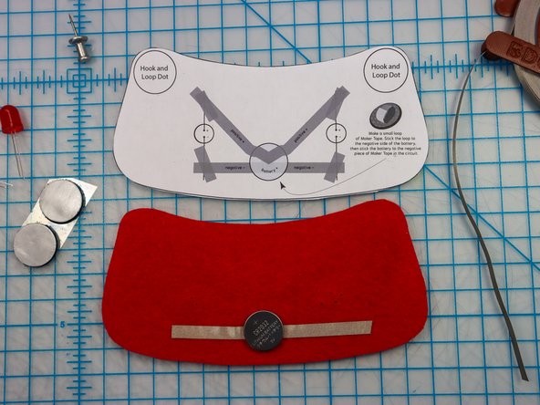 Make a loop of Maker Tape with the adhesive side out and place it on the negative side of the battery.