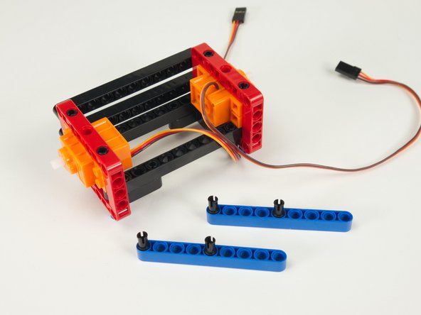 Place black pins into the first and fifth holes of the two blue beams.