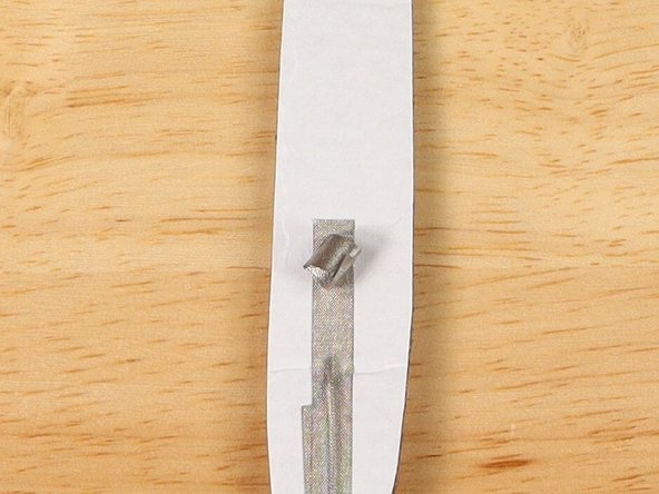 Make a loop of tape (sticky side out) using a short piece of Maker Tape, and stick it atop the end of the path coming from the short (Negative) LED leg.