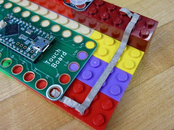 Run Maker Tape from the Ground (White) hole to the back of your LEDs. It will eventually connect up to the Ground (White) side of your LEDs.