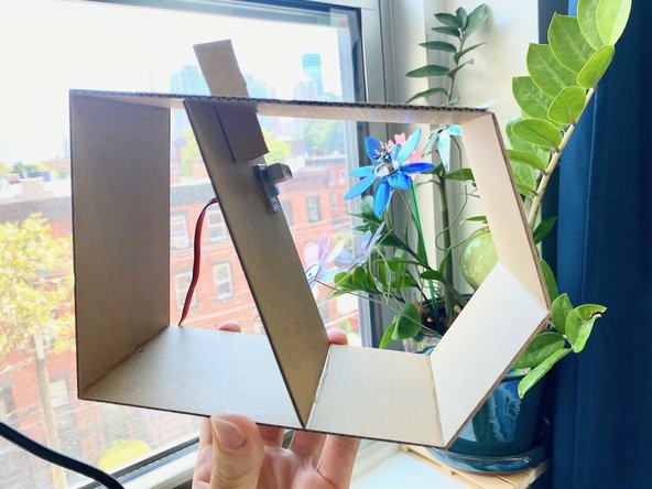 We chose a triangle-shaped hole to focus the opening and closing of the wings, then folded a piece of cardboard to fit inside.