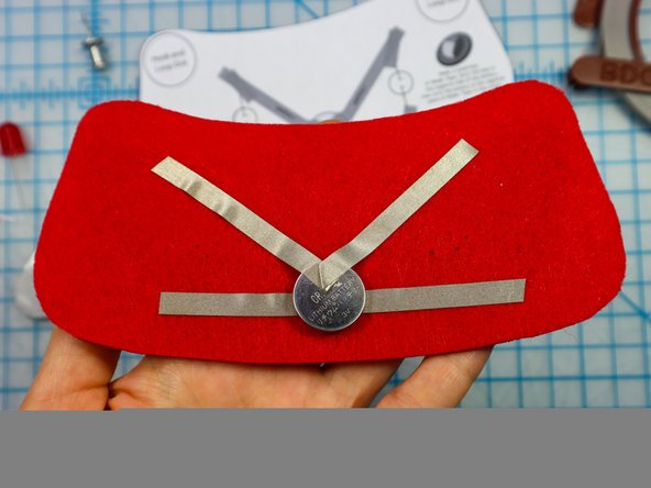 Place the battery on top of the Maker Tape as shown, and add the &quot;V&quot; shaped piece on top.