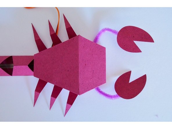 Tape one end of the pipe cleaner to the claw, and the other end to the bottom of the body.