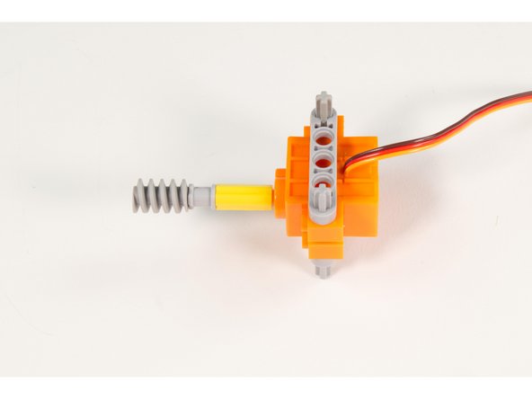Press the LEGO Axle 4 into place, then add the LEGO Bushing and finally the LEGO Worm Gear with New Axle.