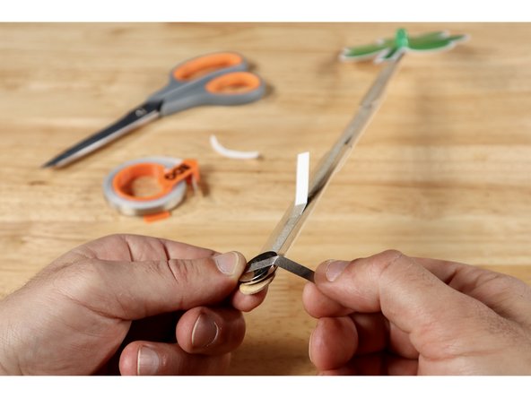 Measure, cut, peel, and stick one final Maker Tape path that reaches from the top of the battery around to the path on the opposite side. The Positive (+) Side of the battery is now connected to the path that leads back up to the Positive (+) LED Leg.