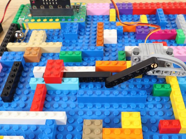 When the ball bearing touches both pieces of tape, the servo will rotate to open the gate and a musical countdown will begin.