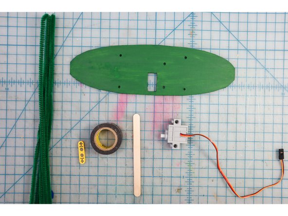 Paint the backplate green to make it blend into the green branches.