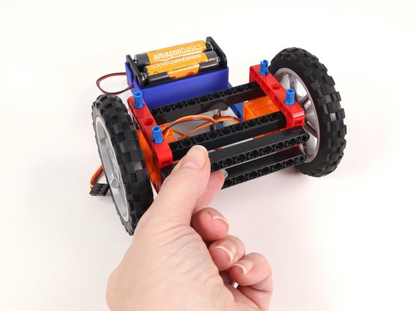 Remove the two long black beams on the front of the Rover as well as the black pins holding them in place.