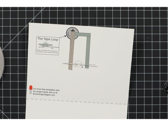 Add a strip of Maker Tape that goes over the negative LED leg and covers about half of the illustration of the battery.