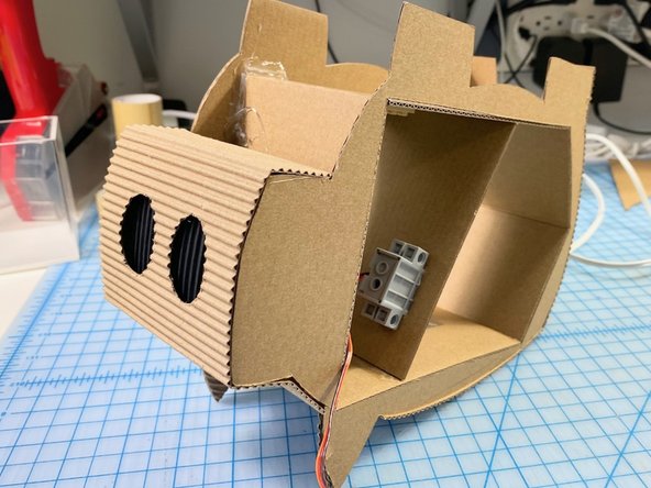 We removed one side from the cardboard to make it bendable and glued it around the exterior of the pig using superglue.