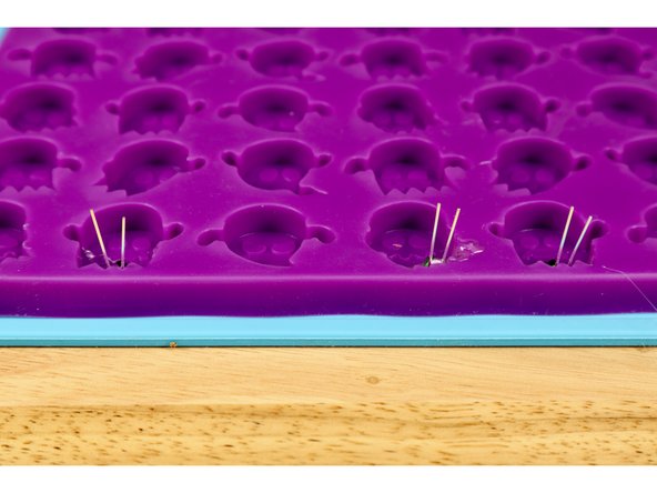 If you've done this correctly, the LED legs will be sticking straight up out of the mold while the LED bulbs have glue below them;  bulb tips pointed toward the ghosts' heads.