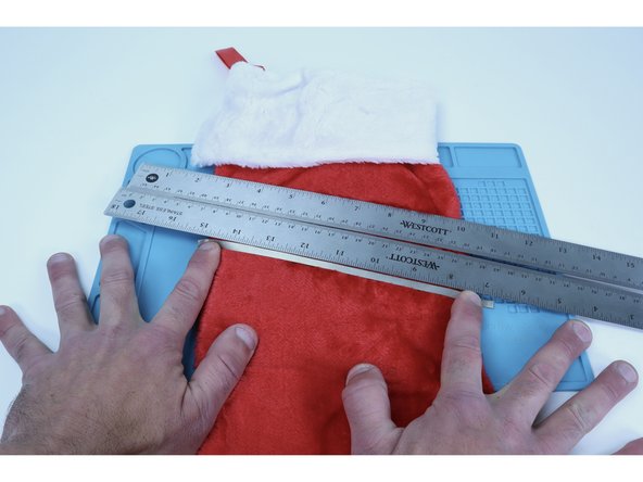 To begin, measure, cut, peel and stick a single pathway out of Maker Tape that goes from stocking edge to edge.