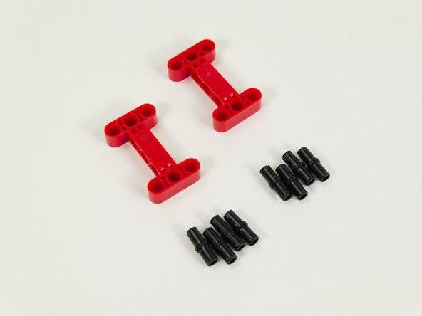 Insert four black pins into each of the red I-shaped beams as shown.